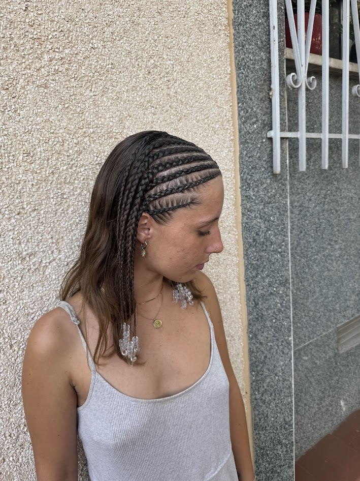 Mujer con trenzas elaboradas posando con estilo